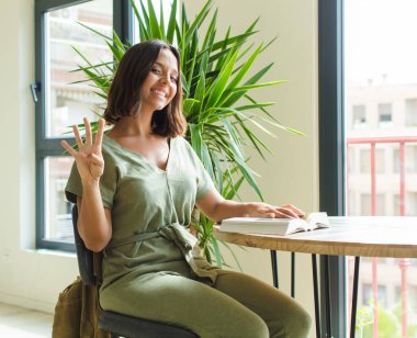 Güzel bir kadın gülümsüyor ve arkadaş canlısı görünüyor, dört ya da dört numarayı gösteriyor, eli önde, geriye doğru sayıyor.