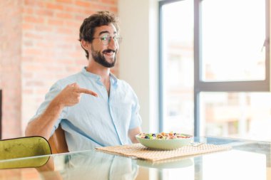 Sakallı adam heyecanlı ve şaşırmış görünüyor. Yana ve yukarıya uzayı gösteriyor.