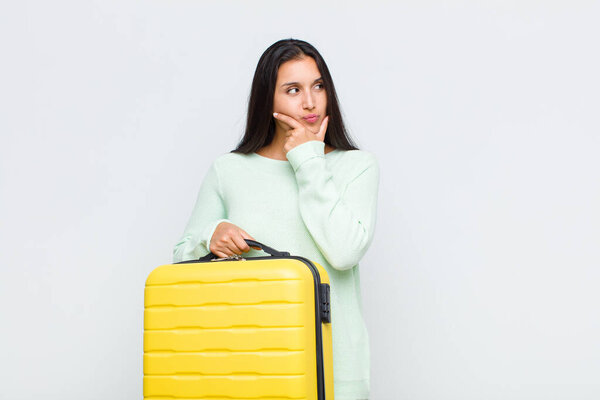 pretty woman thinking, feeling doubtful and confused, with different options, wondering which decision to make