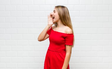 Sarışın kadın profili, mutlu ve heyecanlı görünüyor, bağırıyor ve kenardaki boşluğu kopyalamak için arıyor.