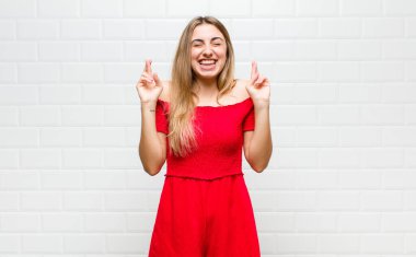 Sarışın kadın gergin ve umutlu, şans diliyor ve dua ediyor.