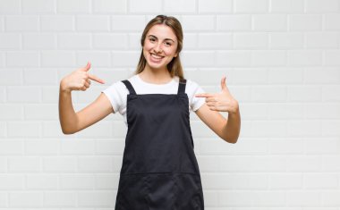 Sarışın kadın gururlu, kibirli, mutlu, şaşırmış ve tatmin olmuş görünüyor, kendini gösteriyor, kazanan gibi hissediyor.