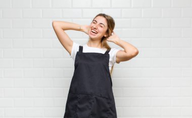 Sarışın kadın gülümsüyor ve rahatlıyor, tatmin oluyor, kaygısız, neşeli ve rahatlatıcı.