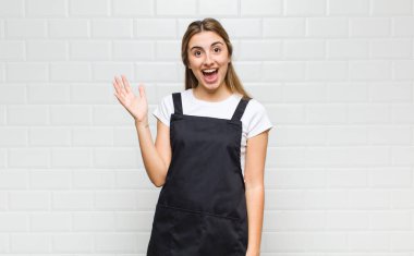 Sarışın bir kadın mutlu, şaşkın ve neşeli, pozitif bir tavırla gülümsüyor, bir çözüm ya da fikri fark ediyor.