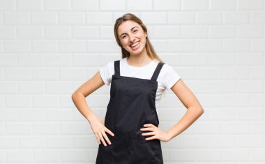 Sarışın kadın neşeli bir şekilde gülümsüyor. Olumlu, mutlu, kendinden emin ve rahat bir ifadeyle.