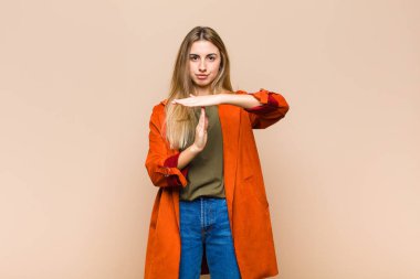 Sarışın kadın ciddi, sert, kızgın ve hoşnutsuz görünüyor.