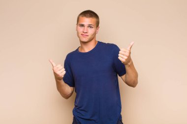 Sarışın adam neşeyle gülümsüyor ve mutlu görünüyor, kaygısız ve pozitif hissediyor.