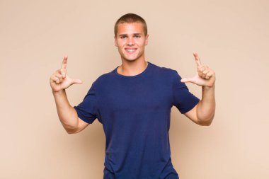 Sarışın bir adam kendi gülüşünü çiziyor, iki eliyle, olumlu ve mutlu görünüyor, sağIık kavramı