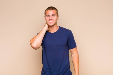 Sarışın adam neşeli ve kendinden emin bir şekilde gülüyor. Sıradan, mutlu, samimi bir gülümsemeyle.