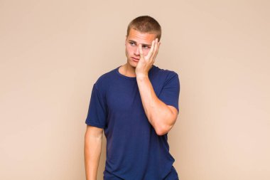 Yorucu, sıkıcı ve can sıkıcı bir işten sonra sıkılmış, hayal kırıklığına uğramış ve uykulu hisseden sarışın bir adam.