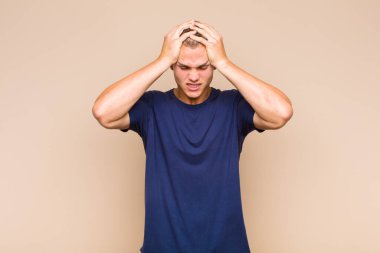 Sarışın bir adam stresli ve hayal kırıklığına uğramış hissediyor. Eli kolu bağlı, yorgun, mutsuz ve migren ağrısı çekiyor.