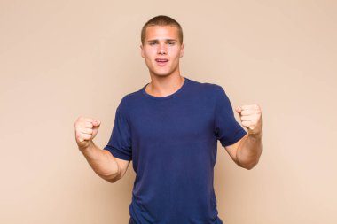 Sarışın adam mutlu, pozitif ve başarılı hissediyor zaferi, başarıları ya da iyi şansı kutluyor.