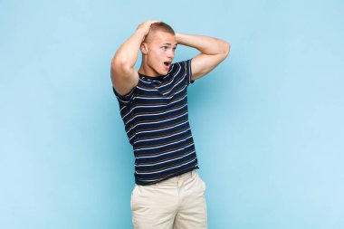 Korkunç bir hata yüzünden dehşete düşmüş ve şok olmuş görünen ağzı açık sarışın bir adam el ele tutuşuyor.