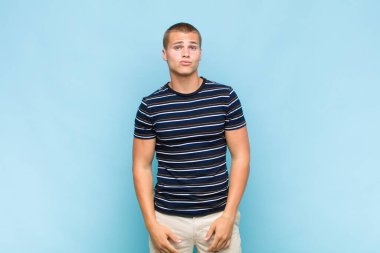 Sarışın adam dudaklarını birbirine bastırıyor, tatlı, eğlenceli, mutlu, sevimli bir yüz ifadesiyle, öpücük yolluyor.