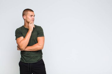 Sarışın adam mutlu bir şekilde gülümsüyor ve hayal kuruyor ya da şüphe ediyor.