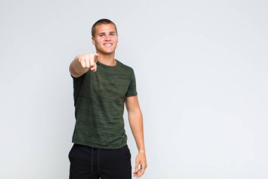 Tatmin olmuş, kendine güvenen, dostça gülümseyen ve seni seçen sarışın bir adam.