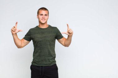 Sarışın bir adam kendi gülüşünü çiziyor, iki eliyle, olumlu ve mutlu görünüyor, sağIık kavramı