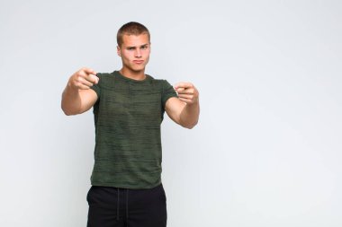 Sarışın adam kamerayı iki parmağıyla ve kızgın bir ifadeyle sana görevini yapmanı söylüyor.