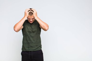 Sarışın bir adam stresli ve hayal kırıklığına uğramış hissediyor. Eli kolu bağlı, yorgun, mutsuz ve migren ağrısı çekiyor.