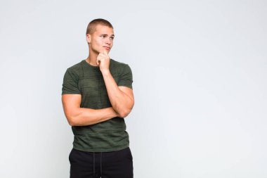 Sarışın adam düşünceli, meraklı ya da hayal kuruyor, hayal kuruyor ve mekanı kopyalamak için yukarı bakıyor.