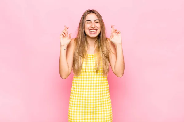 Blonde Woman Smiling Anxiously Crossing Both Fingers Feeling Worried Wishing — Stock Photo, Image