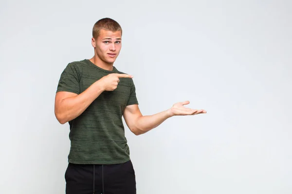 Blonde Man Lachend Vrolijk Wijzend Naar Kopiëren Ruimte Palm Aan — Stockfoto