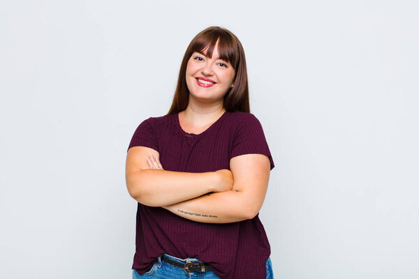 overweight woman laughing happily with arms crossed, with a relaxed, positive and satisfied pose
