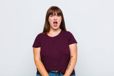 Şişman kadın korkmuş ve şok olmuş hissediyor, ağzı açık şaşkınlık içinde.