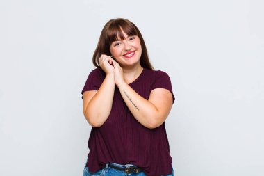 Şişman bir kadın aşık ve sevimli görünüyor. Sevimli ve mutlu. Romantik bir şekilde gülümsüyor.