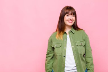 Şişman kadın neşeli, neşeli, mutlu, kendinden emin ve rahat bir ifadeyle gülümsüyor.