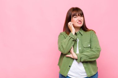 Kilolu bir kadın stresli, hayal kırıklığına uğramış ve yorgun, endişeli ve sorunlu bir bakışla boynunu ovalıyor.