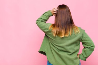 Şişman kadın bilgisiz ve kafası karışık, bir çözüm düşünüyor, eli kalçasında, diğeri kafasında, dikiz aynasından.