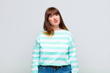 overweight woman feeling puzzled and confused, with a dumb, stunned expression looking at something unexpected
