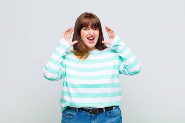 Şişman kadın panik ya da öfke içinde bağırıyor, şok olmuş, korkmuş ya da öfkeli, elleri başının yanında.