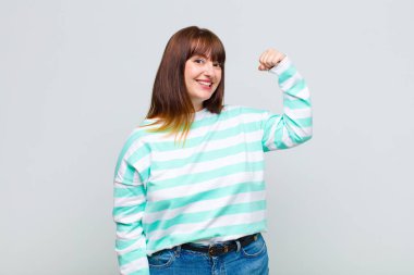 Kilolu kadın kendini mutlu, tatmin olmuş ve güçlü hissediyor, kaslı ve formda, spor salonundan sonra güçlü görünüyor.