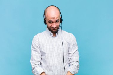 Kel adam gururlu, kendinden emin, havalı, küstah ve küstah görünüyor, gülümsüyor, başarılı hissediyor.