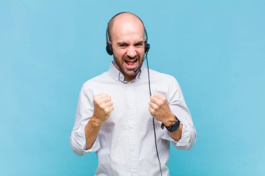 Kel adam zaferle bağırıyor, gülüyor, mutlu ve heyecanlı hissediyor ve başarıyı kutluyor.