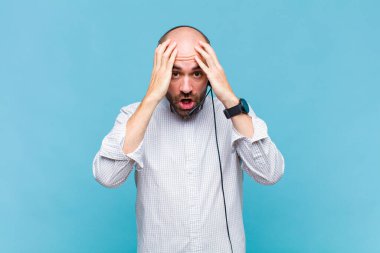 Kel adam dehşete kapılmış ve şok olmuş hissediyor. Elleri havada ve bir hata yüzünden panikliyor.