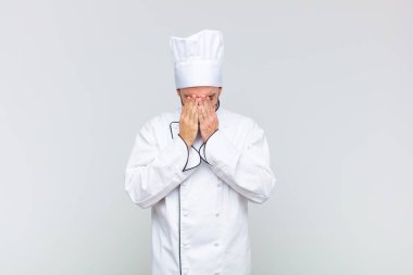 Kel adam üzgün, hayal kırıklığına uğramış, gergin ve depresif, iki eliyle yüzünü kaplayan, ağlayan