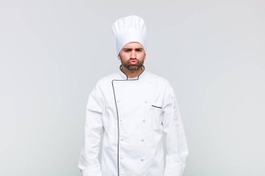 Kel adam dudaklarını birbirine bastırıyor, tatlı, eğlenceli, mutlu, sevimli bir yüz ifadesiyle, öpücük gönderiyor.