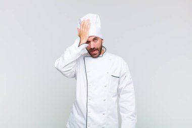 bald man raising palm to forehead thinking oops, after making a stupid mistake or remembering, feeling dumb