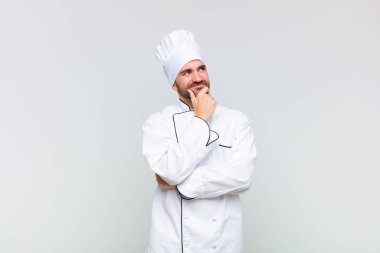 Kel adam düşünceli, meraklı ya da hayal kuruyor, hayal kuruyor ve uzayı taklit etmeye çalışıyor.