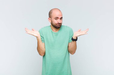 Kel adam şaşkın ve kafası karışık, şüpheci, farklı seçenekleri tartıyor ya da komik bir ifadeyle seçiyor