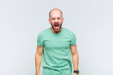 Kel adam agresif bir şekilde bağırıyor, çok kızgın, sinirli, öfkeli ya da sinirli görünüyor, hayır