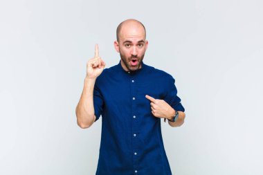 Kel adam kendini gururlu ve şaşırmış hissediyor. Kendine güvenerek kendini bir numara gibi hissediyor.