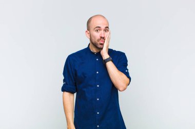 Kel adam şaşkın ve şaşkın hissediyor. Ağzı sonuna kadar açıkken yüz yüze inanmamak için tutuyor.