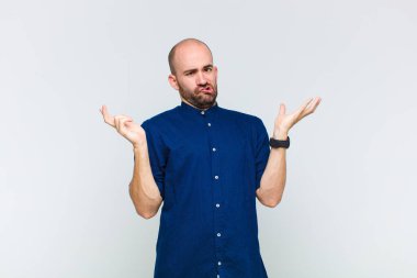 bald man shrugging with a dumb, crazy, confused, puzzled expression, feeling annoyed and clueless