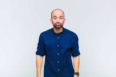 Kel adam dudaklarını birbirine bastırıyor, tatlı, eğlenceli, mutlu, sevimli bir yüz ifadesiyle, öpücük gönderiyor.