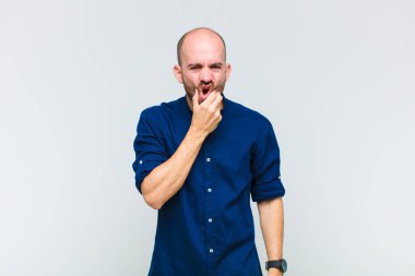 Kel bir adam ağzı ve gözleri sonuna kadar açık ve eli çenesinde, nahoş bir şekilde şokta, ne söylüyor ya da vay be