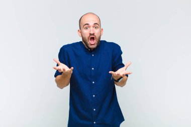 Kel adam son derece şok olmuş ve şaşırmış, endişeli ve panik içinde, stresli ve dehşete düşmüş bir bakışla